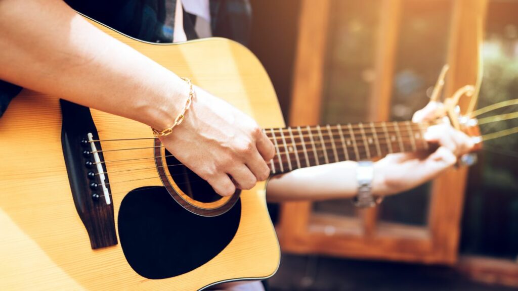 Homme jouant un accord de guitare