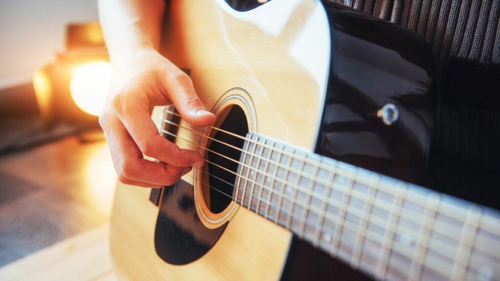 Homme jouant un arpège à la guitare