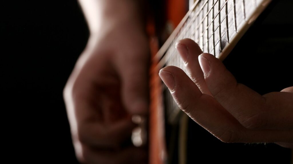 Un homme jouant des harmoniques à la guitare