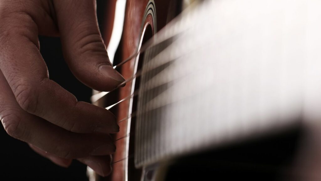 Homme jouant de la guitare en fingerstyle