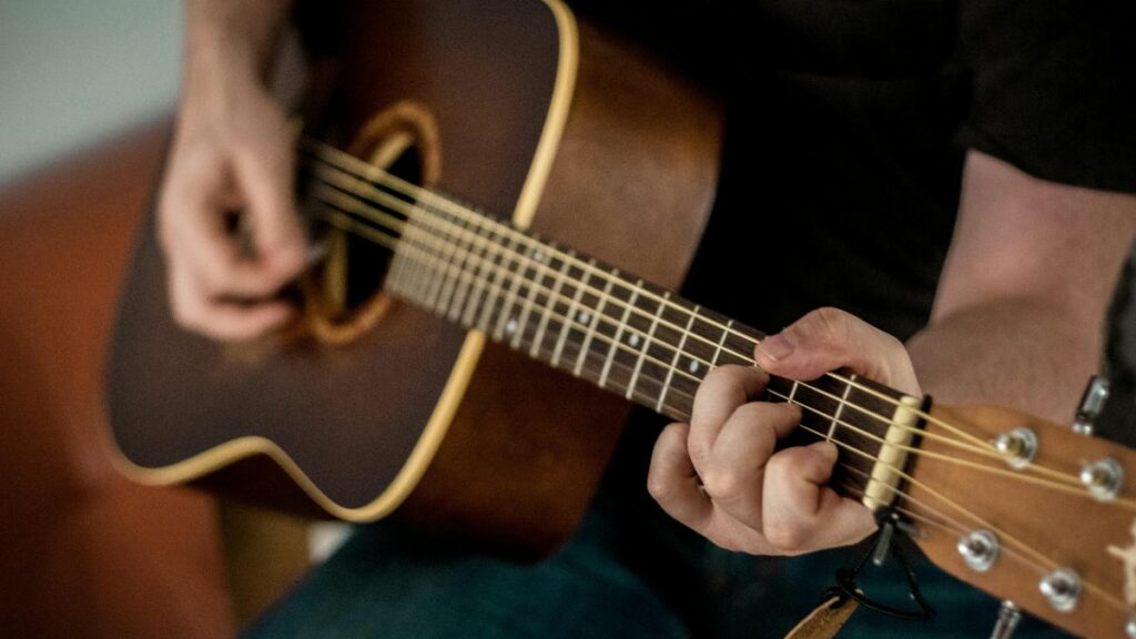 Homme jouant sur une des meilleures guitares acoustiques